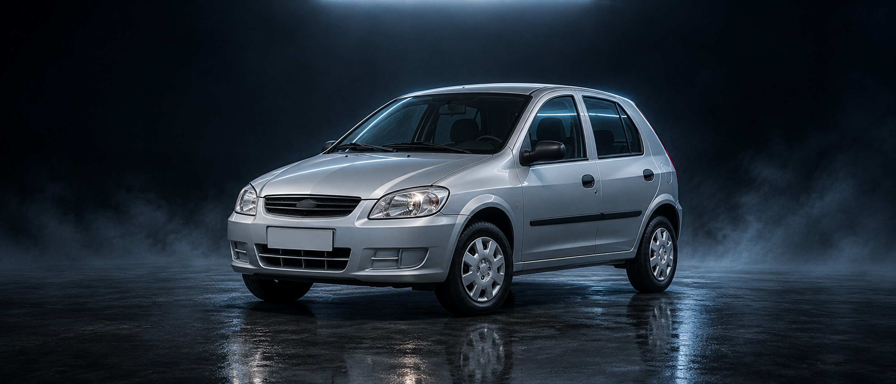 Chevrolet Celta prata em estúdio escuro, com névoa e luz azulada